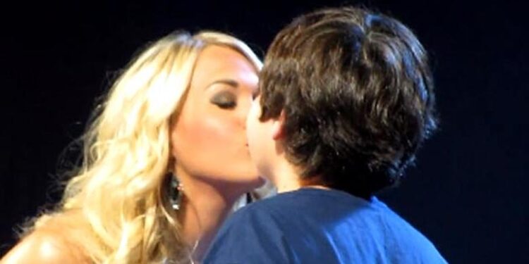 Carrie Underwood Melts Hearts During Her Blown Away Tour In Louisville As She Grants A Brave Young Fan’s Dream On Stage With A Sweet, Unforgettable First Kiss After Spotting His Adorable Sign That Read “Will You Be My First Kiss?”—The Crowd Erupted In Cheers As Carrie Playfully Warned The Audience That Her NHL Star Husband Was In The Building, Adding A Touch Of Humor To The Tender Moment Before Turning To The Blushing Boy And Asking How He’d Like The Kiss To Go, Only To Hear The Bold Response “Lip To Lip”—A Wholesome, Heartwarming, And Completely Unexpected Highlight Of The Night That Left Thousands Smiling, Cheering, And Falling Even More In Love With Carrie’s Down-To-Earth Charm, Kindness, And Magical Connection With Her Fans In A Performance That Will Forever Be Remembered As One Of The Most Endearing Moments In Concert History! Watch Full Video Below!