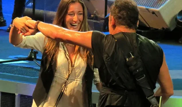 “He’s Tough As Nails On Stage—But Soft As A Father’s Heart When It Comes To Her.” In a moment that sent shockwaves of tenderness through a roaring crowd, Bruce Springsteen—the rock legend known for his gritty anthems and no-nonsense swagger—set down his guitar, reached out his hand, and gently pulled his daughter into a dance under the stadium lights. For a few breathtaking minutes, the man who’s spent decades ruling stages and selling out arenas wasn’t The Boss—he was simply a dad, swaying slowly with his little girl in front of hundreds of thousands of fans. The cameras caught it all: his weathered face softening, his eyes misting over, and his arms holding her like the most precious melody he’d ever written. “That’s the real Bruce,” one fan whispered through tears. “Cold to the world when he needs to be… but gentle, completely gentle, with just one girl.”