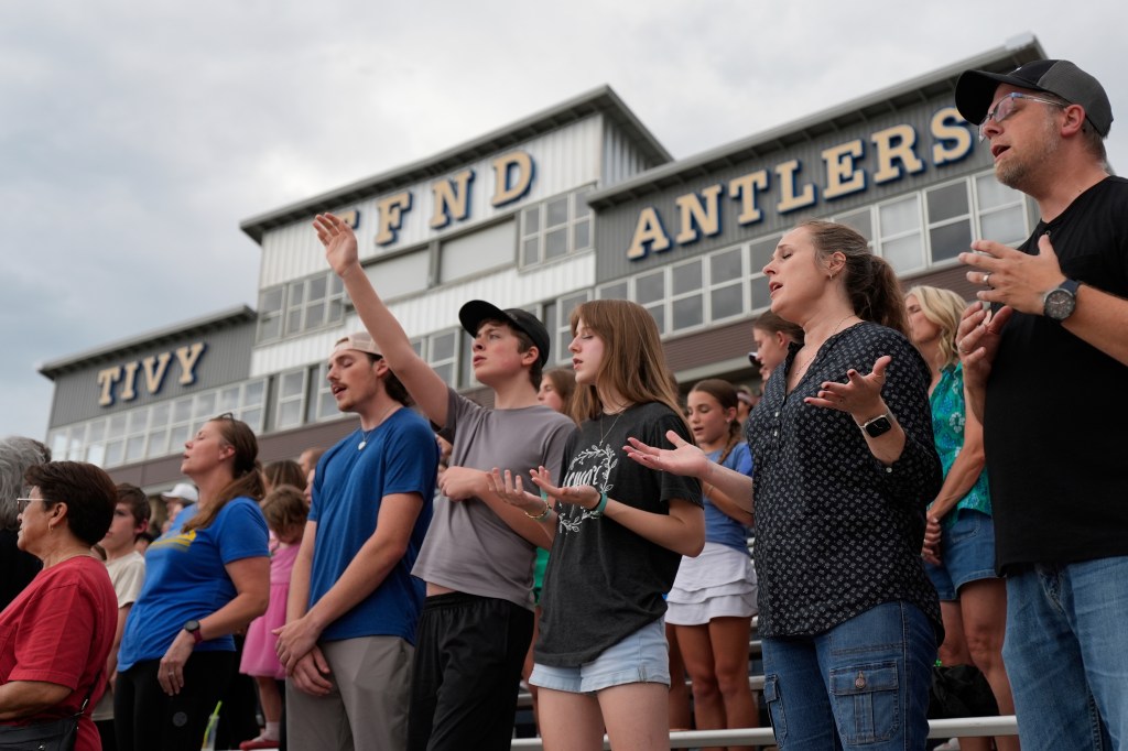 People praying at a vigil for flood victims.
