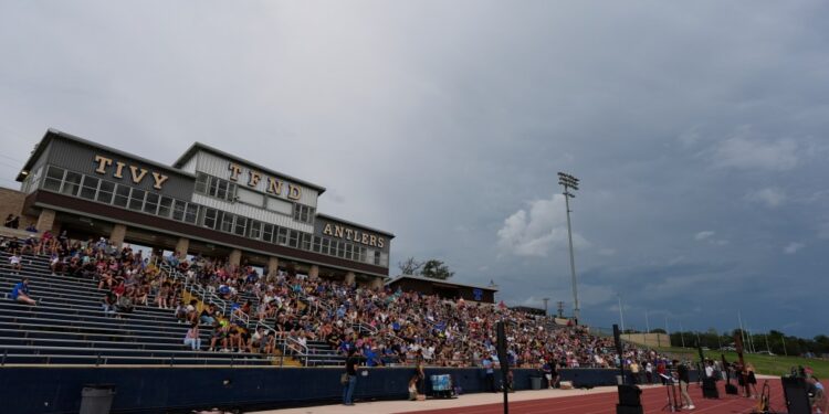 Hundreds came together at a Texas high school stadium to honor the lives lost in the floods. The mood was heavy—families held photos, candles flickered, and tears flowed. Then, without warning, Tom Brady walked onto the stage. No spotlight, no big entrance—just him. When he spoke, the crowd went silent. His voice cracked as he talked about loss, pain, and healing. People cried. They hugged each other. And in that moment, something shifted. Brady didn’t just bring words—he brought hope. Under the lights, grief began to turn into strength.