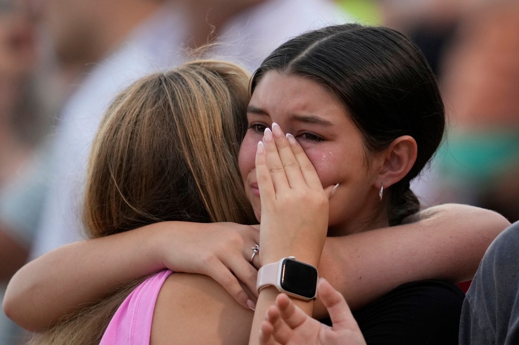Two girls hugging, one crying.
