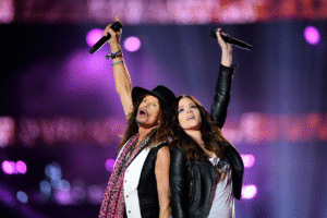 Steven may not have ever found true love with a woman, but he sure does love his kids, doesn’t he. In a moment the rock world never expected, he revealed his heart on stage in the simplest, most moving way. No wild spins, no ear-shattering screams—just a duet. His partner? Chelsea, his daughter who has largely stayed out of the public eye. From the very first note, the audience fell silent—not in awe of technique, but in awe of raw, unfiltered emotion. Every word carried warmth and ache, a father and daughter reconnecting in melody. Steven’s gaze lingered on Chelsea as if discovering a part of his soul he had never dared touch, while Chelsea’s voice shimmered with the innocence and love of the little girl he once rocked to sleep. For anyone who has only known Steven Tyler as a larger-than-life rock god, this intimate performance will forever change that perception