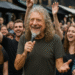 In a magical street-side encounter at Camden Market, Robert Plant was spotted smiling as a group of fans passionately sang “Stairway to Heaven.” To everyone’s amazement, he gently took their microphone and delivered the soaring final notes himself, leaving the crowd stunned and exhilarated. Eyewitnesses say his warmth and spontaneity created an unforgettable, intimate moment that blurred the line between rock legend and everyday fan. Clips of the unexpected duet quickly spread across social media, garnering millions of views and leaving fans around the world in awe. Sources reveal Robert chatted and laughed with the fans afterward, soaking in their excitement and admiration. Insider accounts hint at playful gestures and nods that made the performance feel personal yet epic. By the end, Camden Market buzzed not just with music, but with the pure thrill of a once-in-a-lifetime rock encounter.